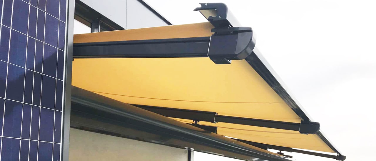 Glasdachmarkise aussen auf dem Glasdach mit gelbem Tuch und schwarzer Führungsschiene