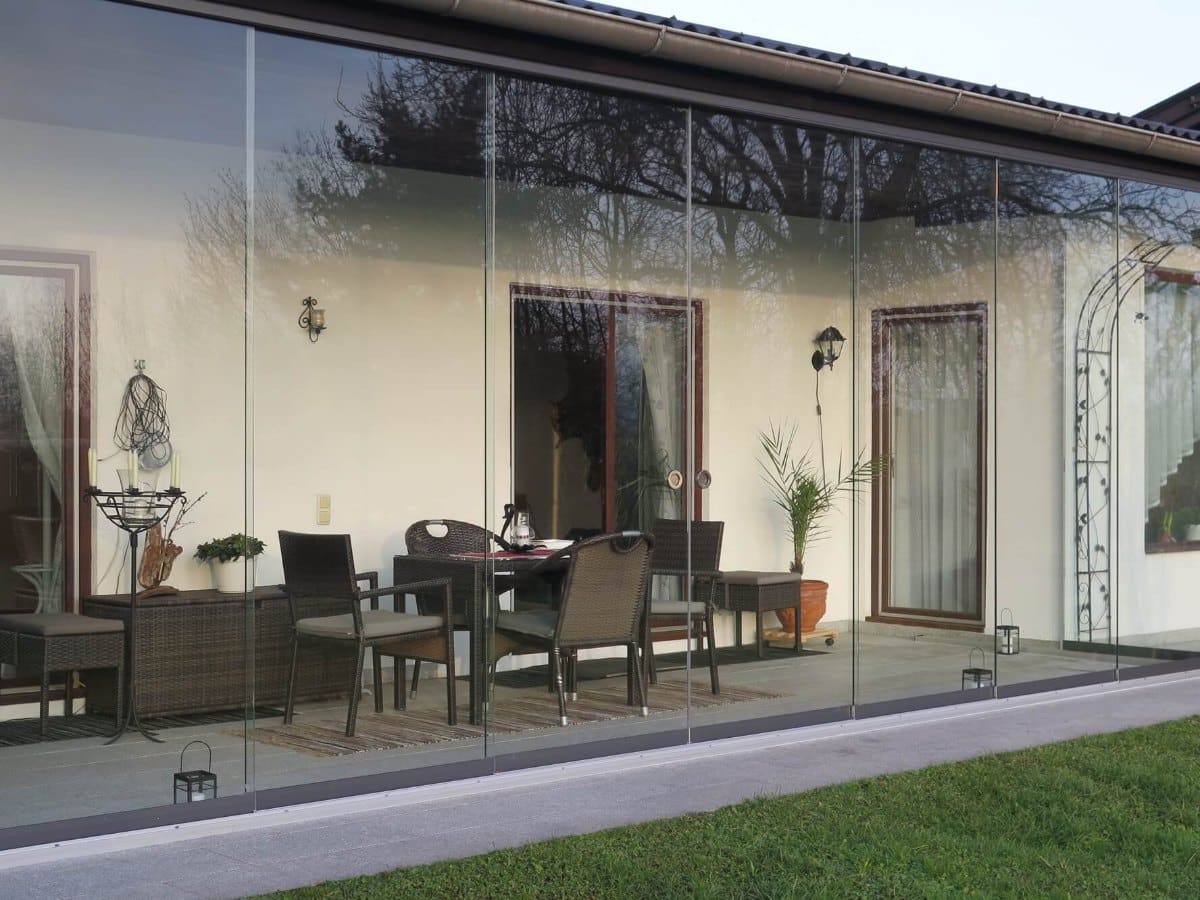 Rahmenlose Glasschiebeelemente in Anthrazit DB 703 vor einer Terrasse mit Sitzplatz in Vöcklabruck