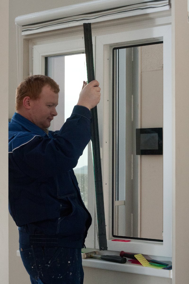 Leerer Flügelrahmen des Kunststofffensters, Glaser prüft Glasfalz und Glasleisten