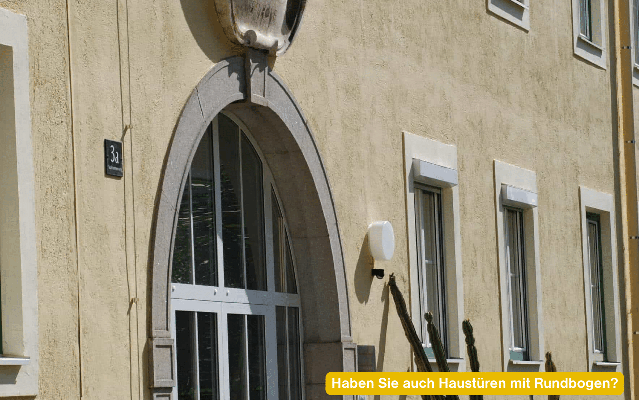 Haben Sie auch Haustüren mit Rundbogen? Weiße Aluminium-Eingangstür mit Rundbogen an einem historischen Gebäude