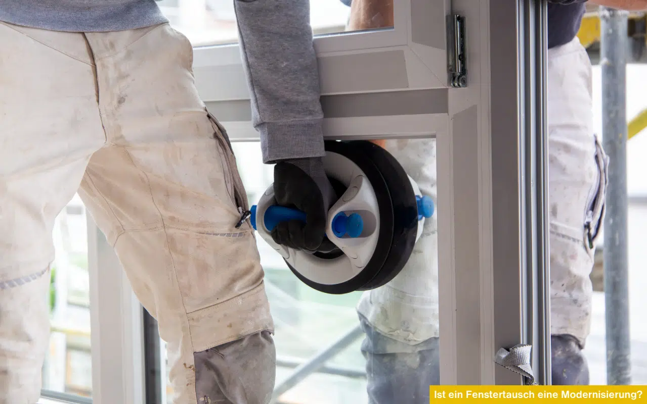 Handwerker montieren Fenster mit Saugheber. Ist ein Fenstertausch eine Modernisierung? Energieeffizienz verbessern.