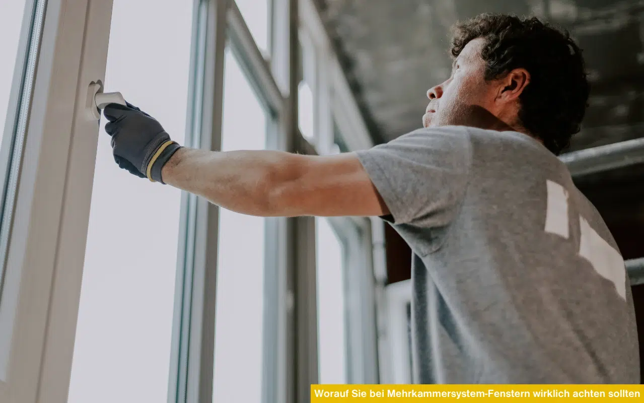 Handwerker prüft den Fenstergriff eines neu eingebauten Mehrkammersystem-Fensters. Fokus auf Montagequalität und Stabilität.