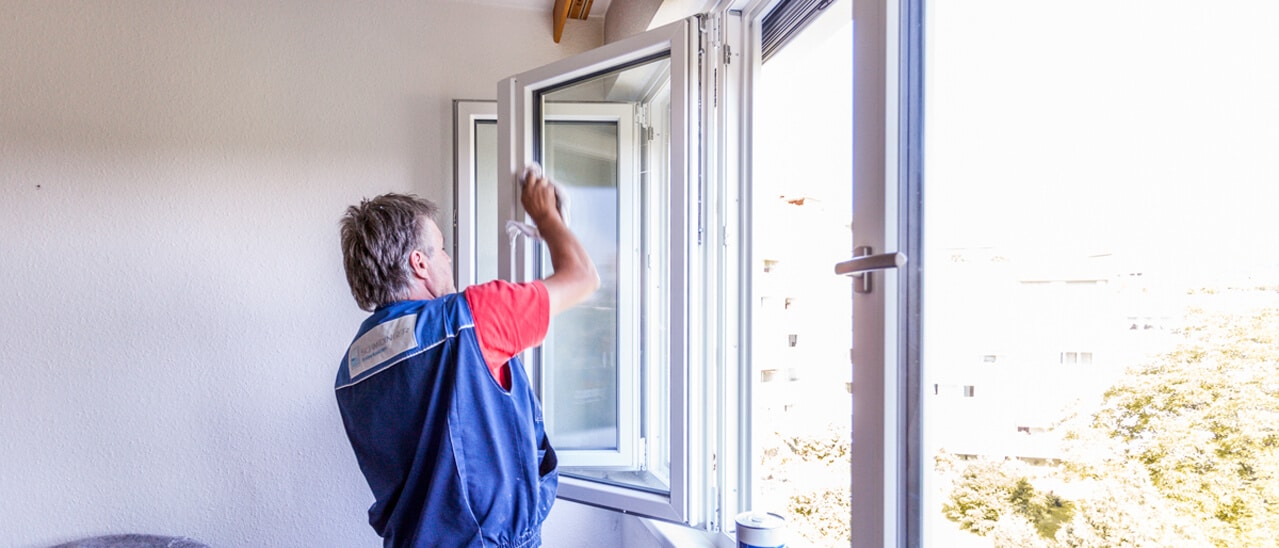 Handwerksqualität Fenster - Monteur reinigt nach der Montage den Flügel eines Kunststofffensters