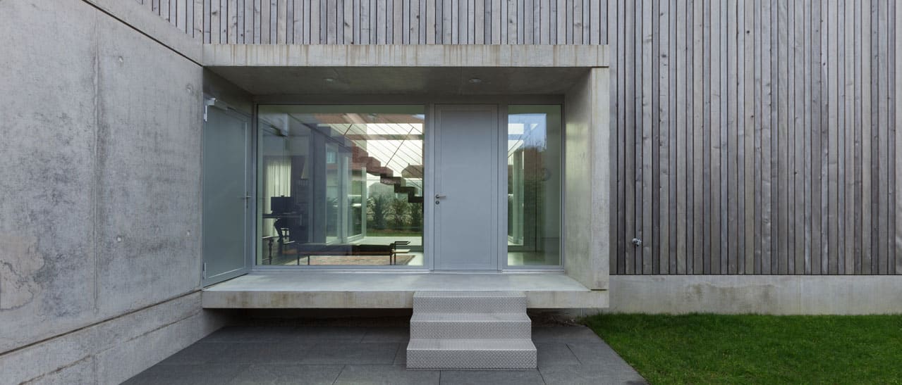 Trends bei den Haustüren-Farben: Hellgraue Haustür mit Seitenteil, passend zum modernen Stil des Hauses.