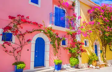 Bunte Häuser mit kräftigen Haustürenfarben in einem südlichen Land, zeigen die Trends bei den Haustüren-Farben im Jahr 2023.