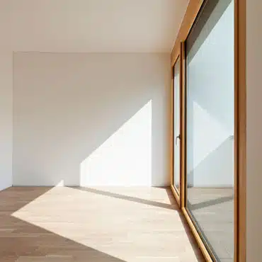 Helle Holz-Aluminium Balkontüre mit Seitenteil, die viel Licht hereinlässt und offene, freundliche Wohnräume schafft.