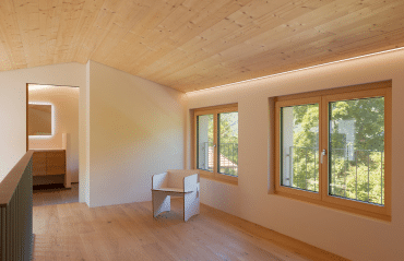 Heller Raum mit Holzdecke und zwei Holzfenstern. Neue Fenster im Bezirk Perg sorgen für natürliches Licht.