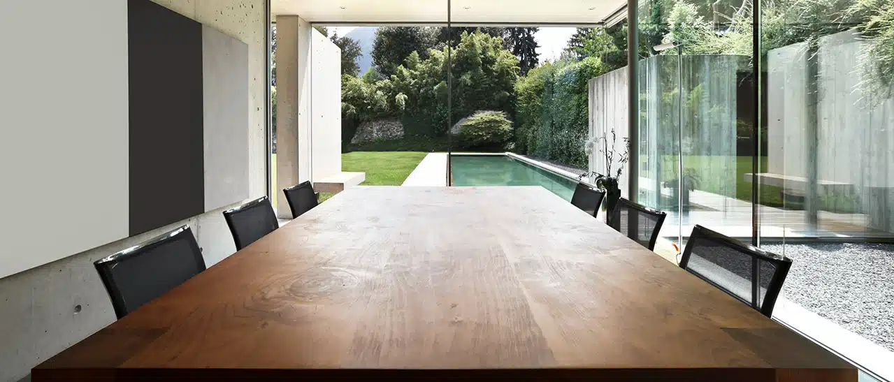 Sommergarten mit Holztisch und Stühlen, betont Bedeutung von Qualität bei der Materialwahl.