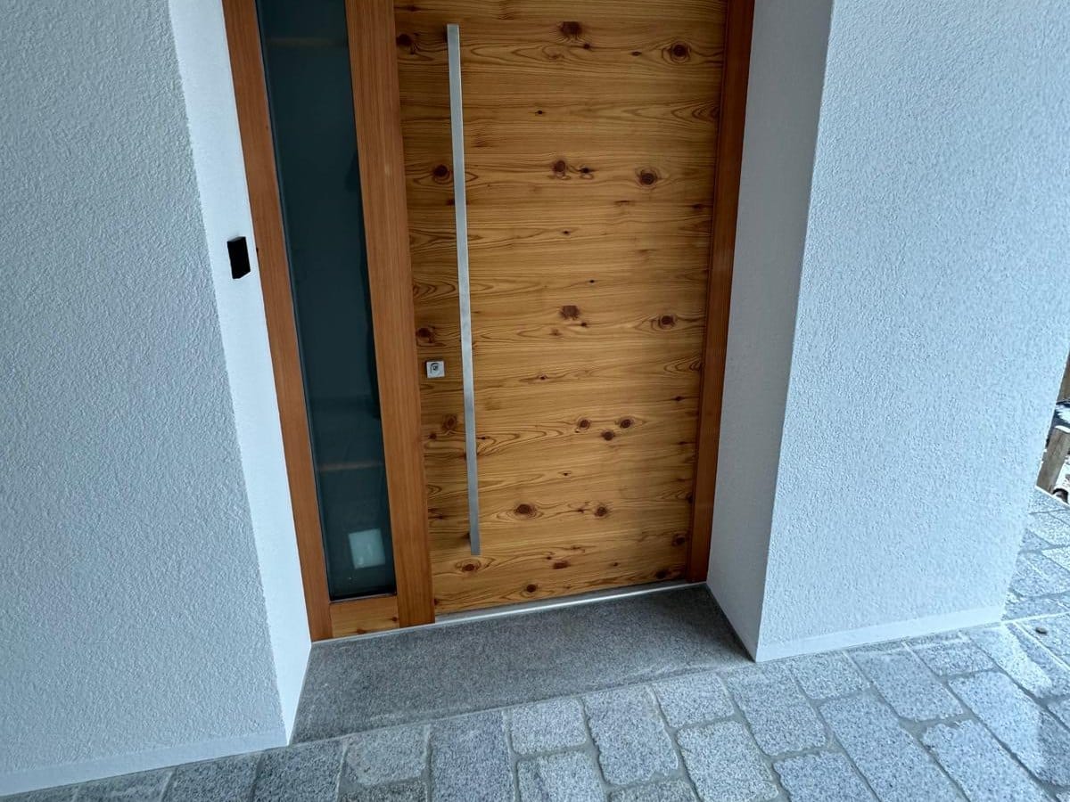 Moderne Holz-Haustür in astiger Lärche mit Glas-Seitenteil