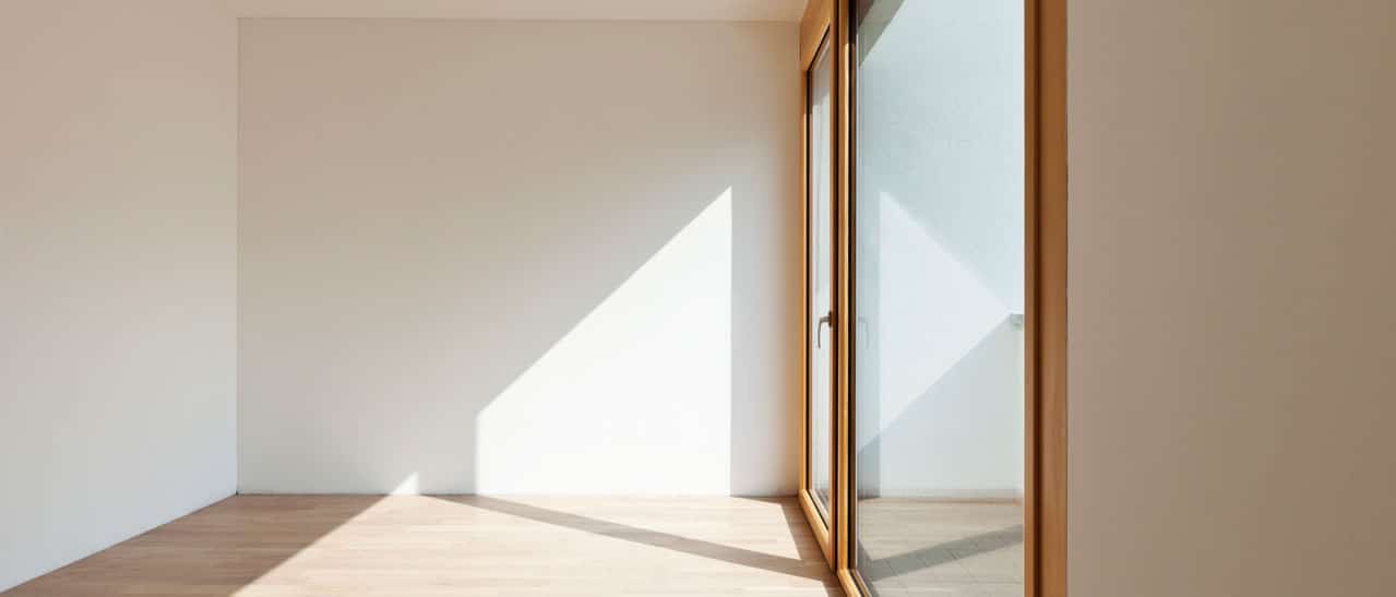 Innenansicht einer modernen Holz-Aluminium Balkontüre mit Seitenteil, die viel Lichteinfall und Helligkeit für helle Wohnräume bietet.