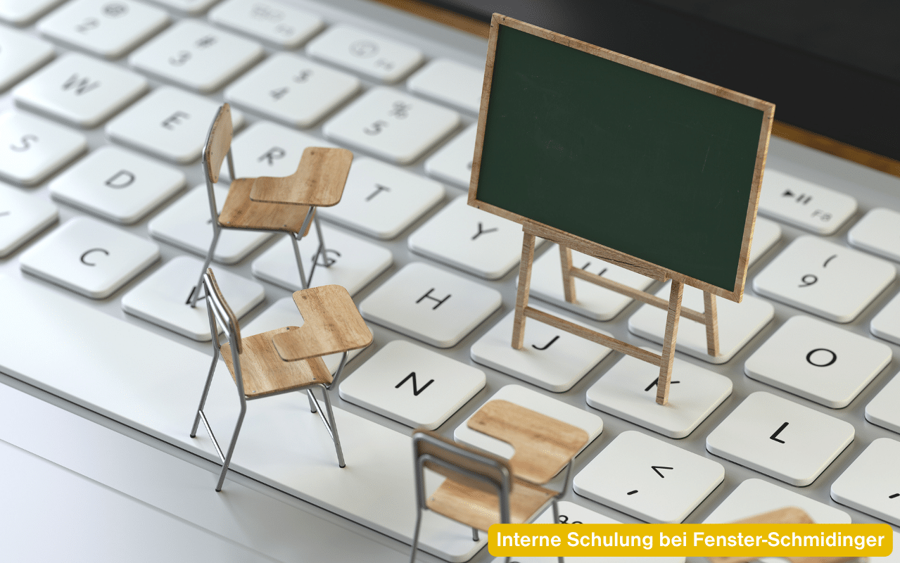 Interne Schulung bei Fenster-Schmidinger mit kleinen Stühlen und Schultafel auf einer Computertastatur