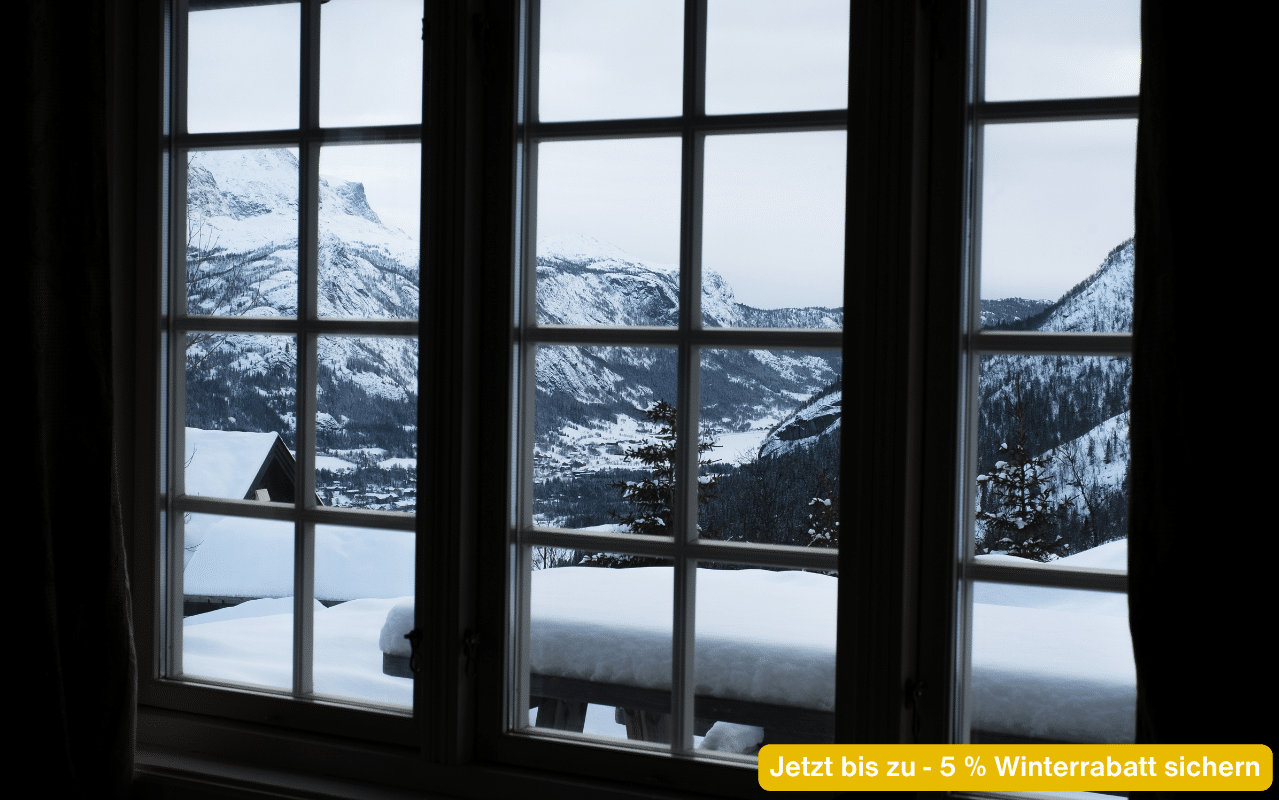 Jetzt bis zu - 5 % Winterrabatt sichern – Fenster mit Blick auf verschneite Berglandschaft im Winter