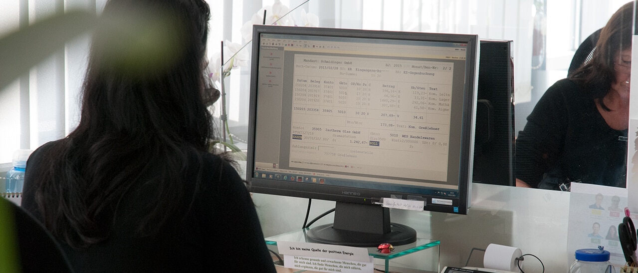 Eine Mitarbeiterin am Computerarbeitsplatz bei Fenster-Schmidinger erstellt technische Zeichnungen und Kalkulationen.