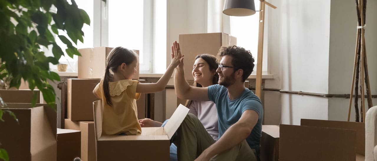 Junge Familie zieht in neue Wohnung mit modernen Wohnungsfenstern ein und freut sich auf Zuhause.