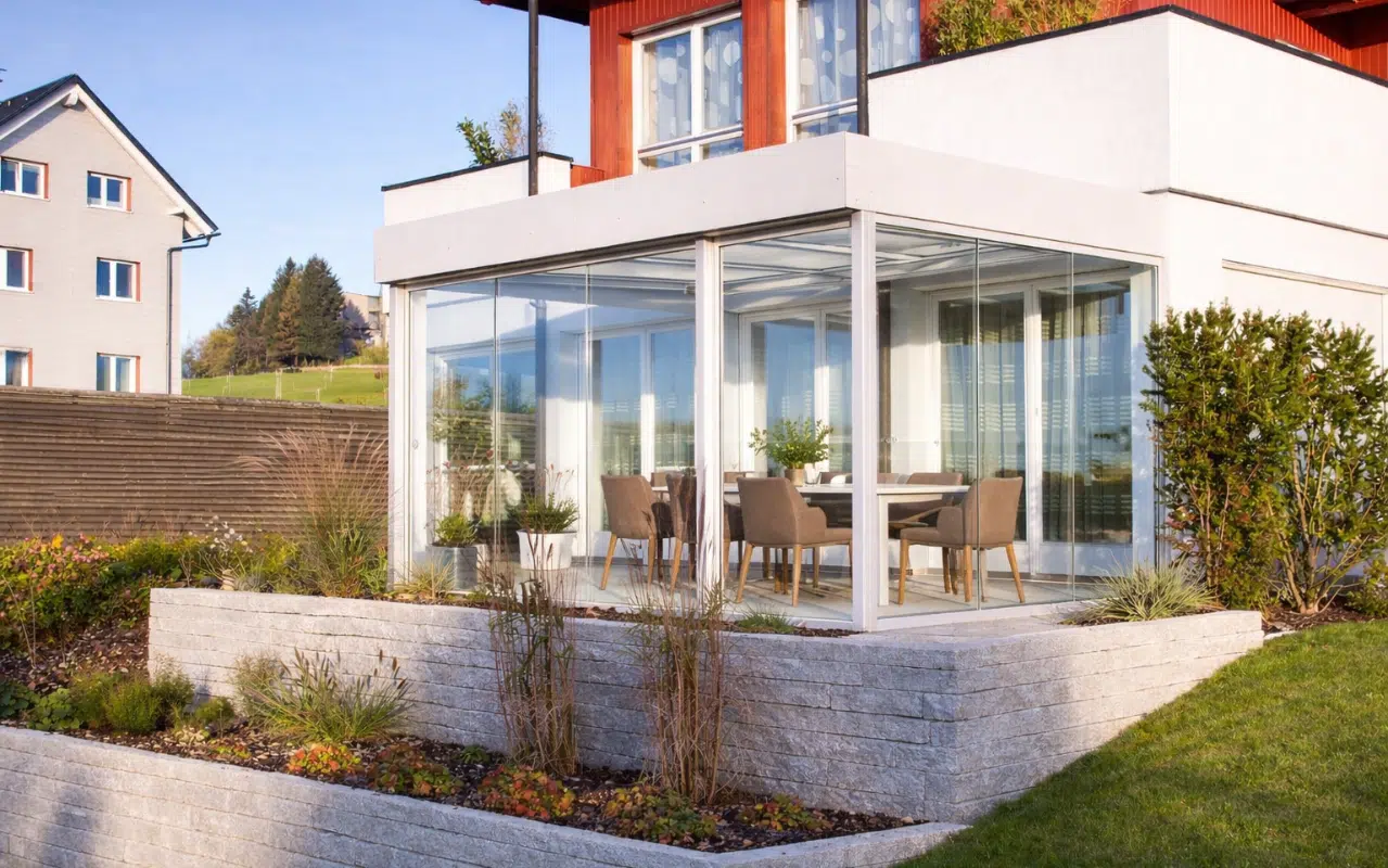 Kaltwintergarten als gläserne Terrassenüberdachung für geschützte Zeit im Freien und zum Überwintern von Pflanzen.