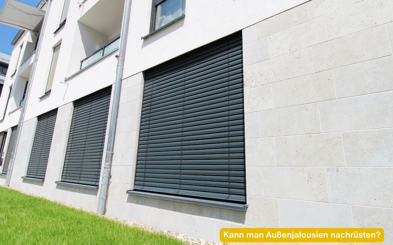 Kann man Außenjalousien nachrüsten? Wohnhausfassade mit heruntergelassenen Außenjalousien