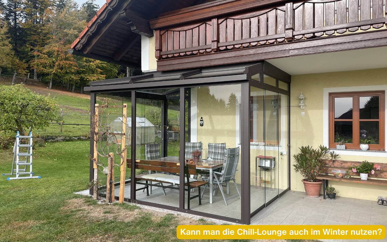 Kann man die Chill-Lounge auch im Winter nutzen? Kaltwintergarten mit gerahmten Schiebetüren unter einem Holzbalkon