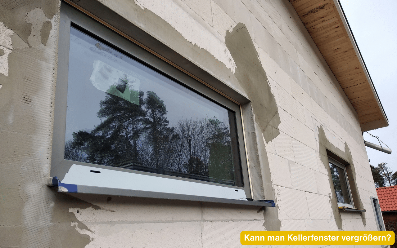 Kann man Kellerfenster vergrößern? Breites neues Fenster in einer Rohbaufassade aus hellen Porenbetonsteinen