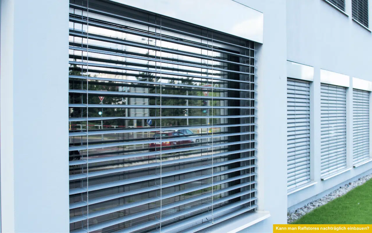 Das Foto zeigt nachträglich montierte Raffstores an Fenstern – als Beispiel für eine nachträgliche Außenbeschattung am Gebäude.
