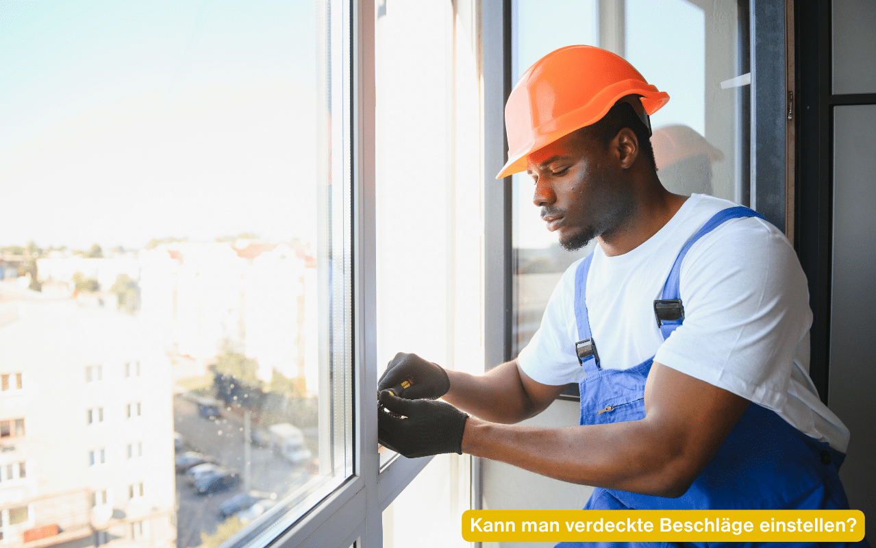 Kann man verdeckte Beschläge einstellen? Monteur mit Schutzhelm arbeitet an einem Fensterflügel