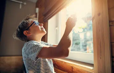 Neues Kellerfenster: Ein Kind betrachtet stolz das frisch ausgetauschte Kellerfenster in Oberösterreich. Kellerfenster austauschen.