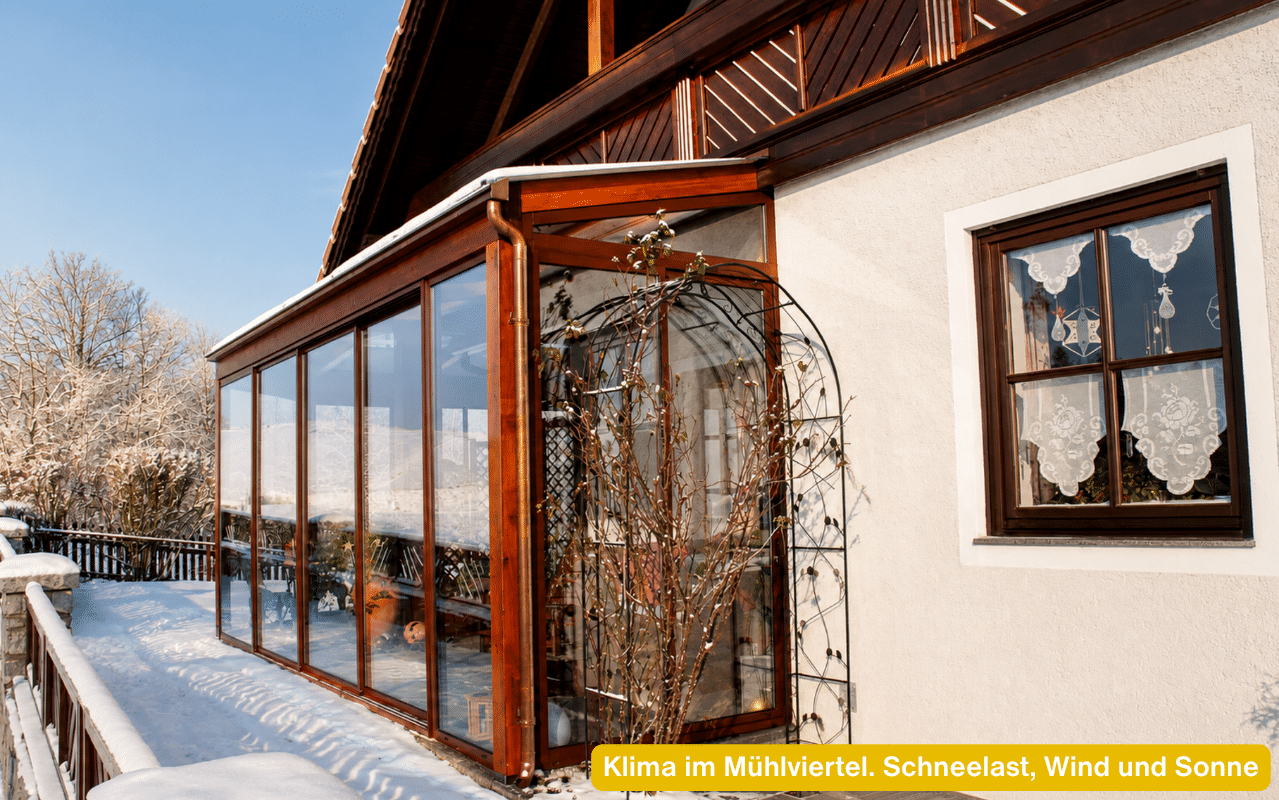Klima im Mühlviertel. Schneelast, Wind und Sonne prägen diesen Holz-Wintergarten mit Schnee am Dach
