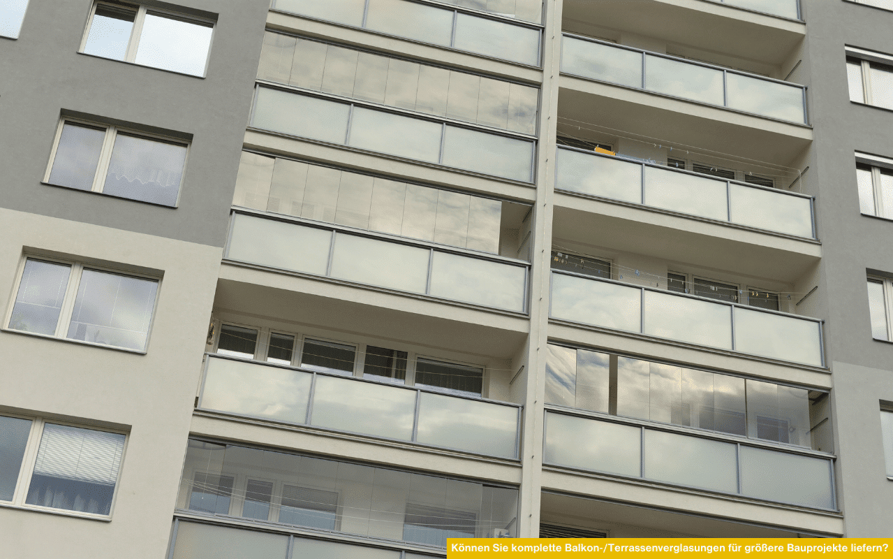 Mehrere übereinanderliegende Balkone eines Wohnblocks sind mit durchgehenden Glasverkleidungen ausgestattet, die eine einheitliche Optik schaffen.