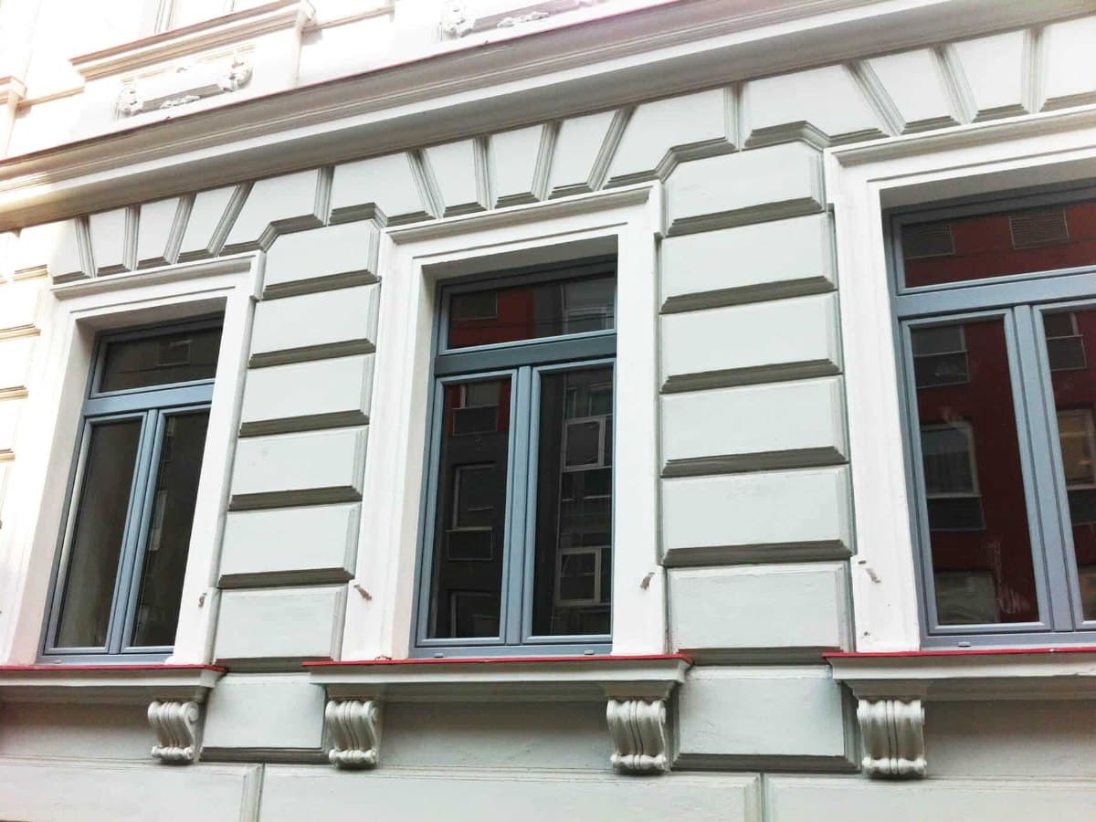 Altbaufassade mit neuen Kunststoff-Alu-Fenstern in Grau, Fenstertausch bei der Sanierung in Oberösterreich