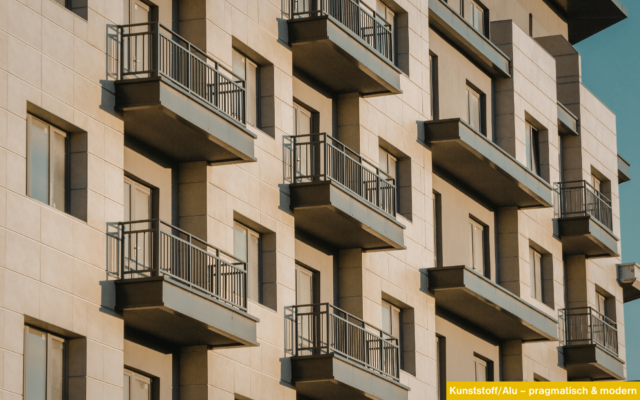 Moderne Wohnanlage mit Kunststoff-Aluminium-Fenstern in RAL 1019 und Balkonen an einer hellen Fassade.