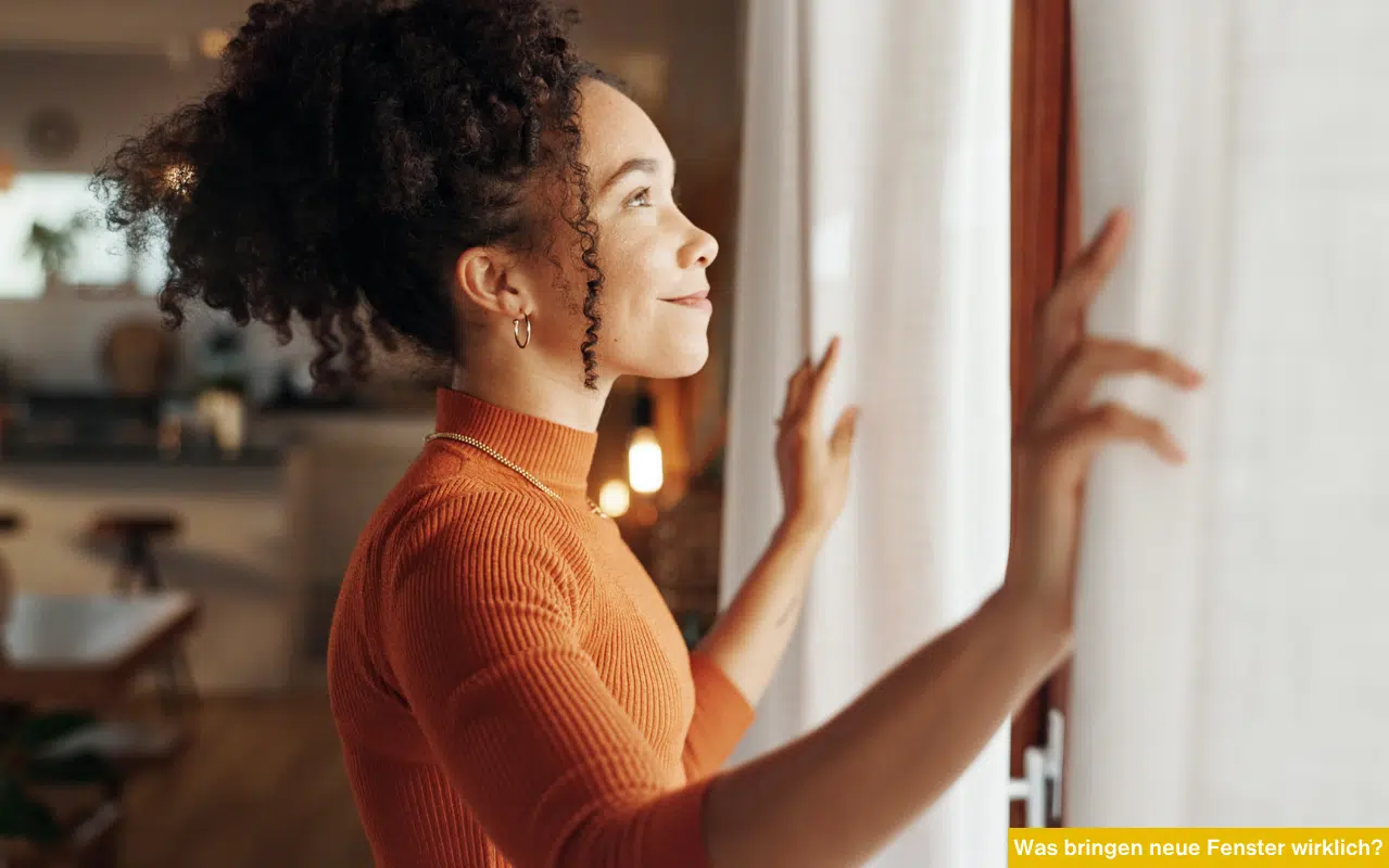Lächelnde Frau blickt durch helles Fenster. Was bringen neue Fenster wirklich? Energieeffizienz und Wohnkomfort steigern.