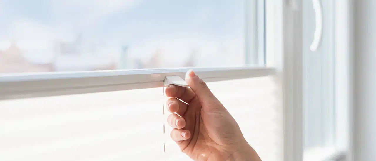 Frau bedient kinderleicht ein Plissee, Detailbild der einfachen Handhabung.