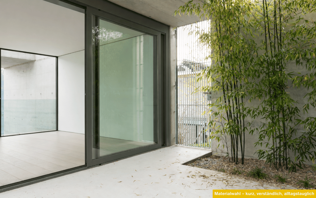 Moderne Schiebetür mit Grüngrauem Aluminiumrahmen und Blick in einen ruhigen Innenhof.