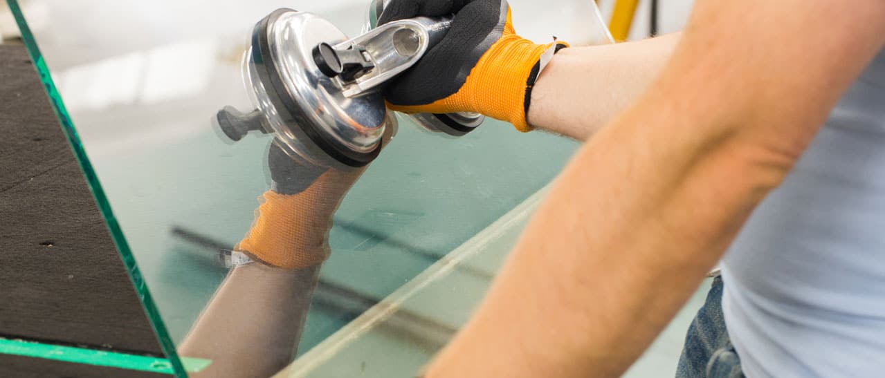 Glaser von Fenster-Schmidinger setzt mit einem Saugnapfheber eine neue Glasscheibe ein - Glaserarbeiten in Linz und Oberösterreich