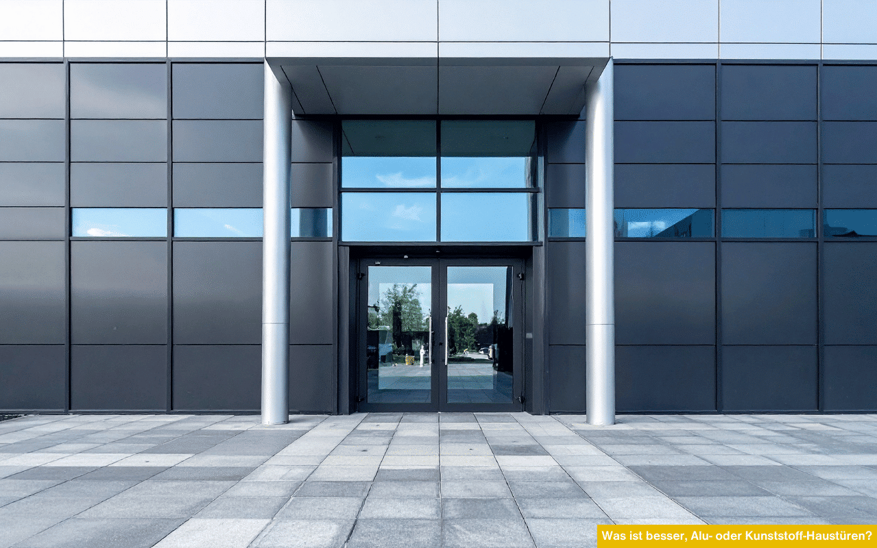 Moderne Eingangstür aus Aluminium in Glasfassade veranschaulicht die Frage: Was ist besser, Alu- oder Kunststoff-Haustüren?