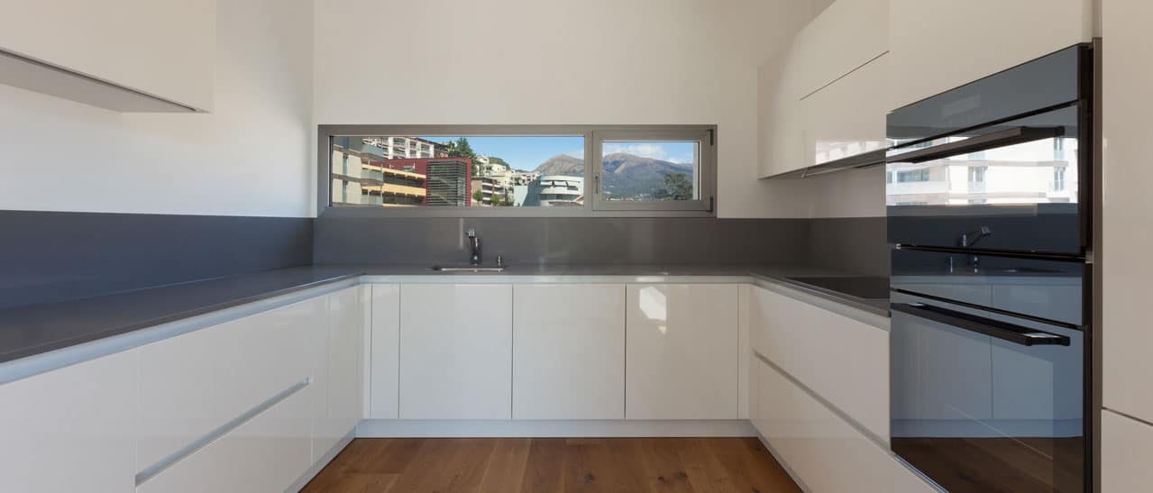 Moderne U-förmige Küche mit schmalen querliegenden Fenstern für natürliches Licht.