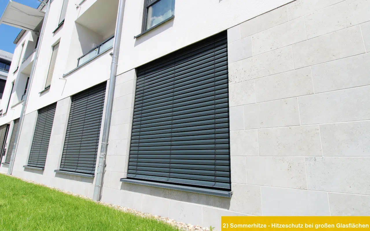 Modernes Gebäude mit großen Glasflächen und dunklen Außenraffstoren. Hitzeschutz im Sommer durch effektive Beschattung.