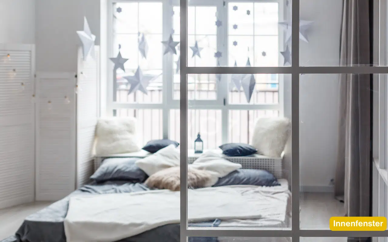 Modernes Innenfenster im Wohnbereich und Büro trennt Räume lichtdurchlässig. Weißes Sprossenfenster vor hellem Zimmer.