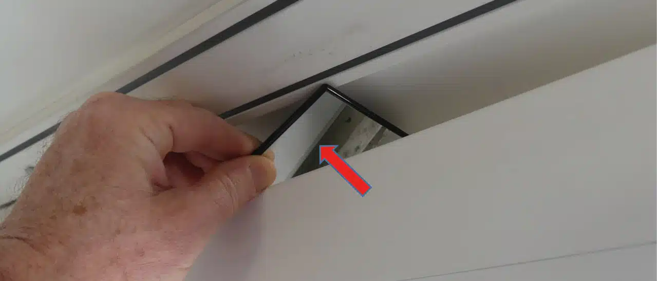 Ein Sachverständiger überprüft mit einem kleinen Spiegel, ob die Fensterdichtungen des Flügelprofils auf dem Rahmen ordentlich anliegen.