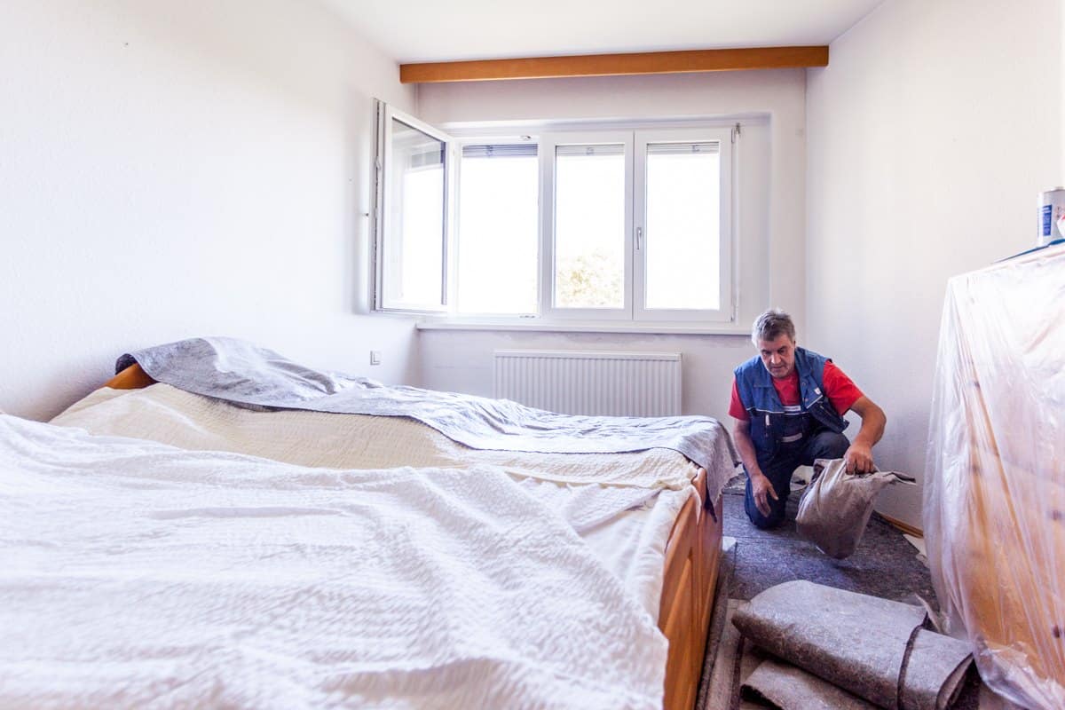 Neues Fenster fertig montiert, der Monteur räumt das Schutzvlies zusammen