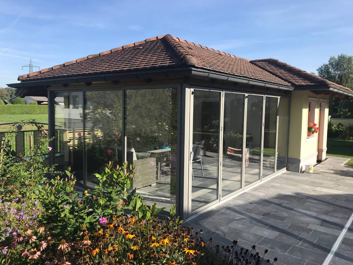 Gartenpavillon mit Ziegeldach und Terrassenverglasung aus Faltwand und Schiebesystem