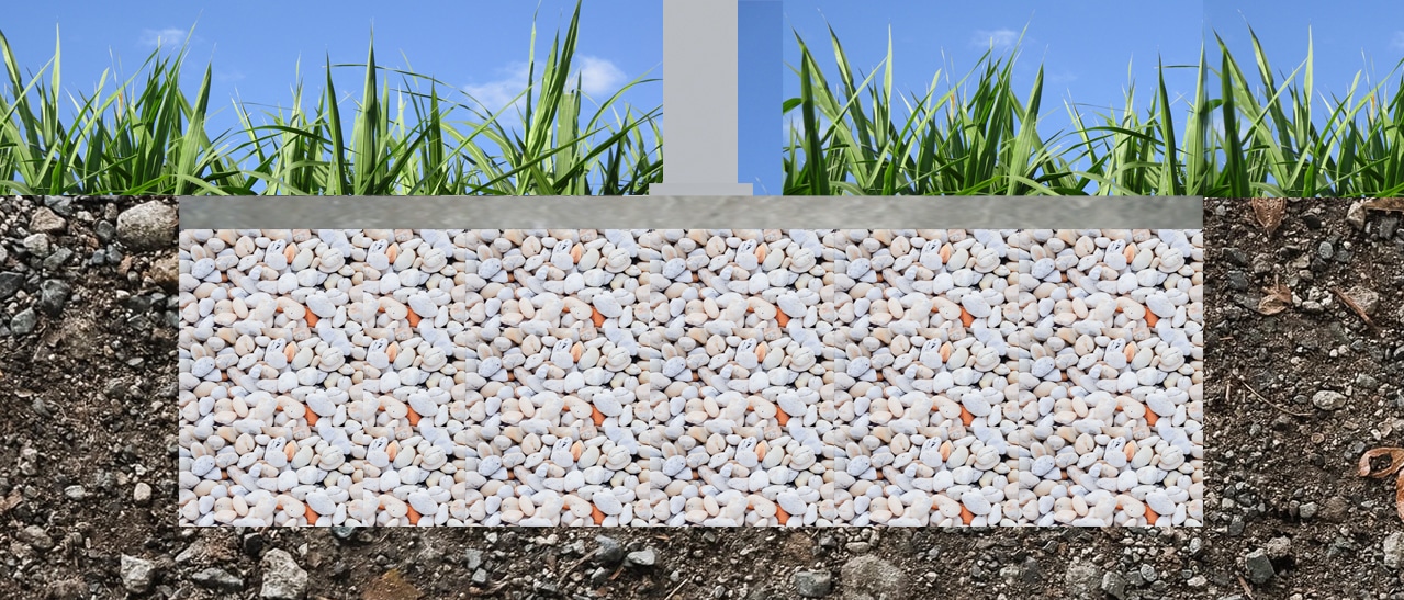 Das Bild zeigt ein Querschnittsmodell eines Plattenfundaments. Unter der Grasnarbe ist eine dicke Schotterschicht erkennbar, die von einer Betonplatte abgedeckt wird - ideal zur Lastverteilung bei größeren Bauwerken.