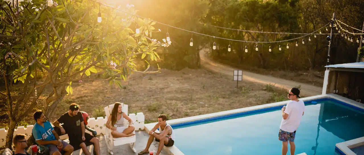 Freunde und Familie entspannen am Pool an einem gemütlichen Sommerabend.