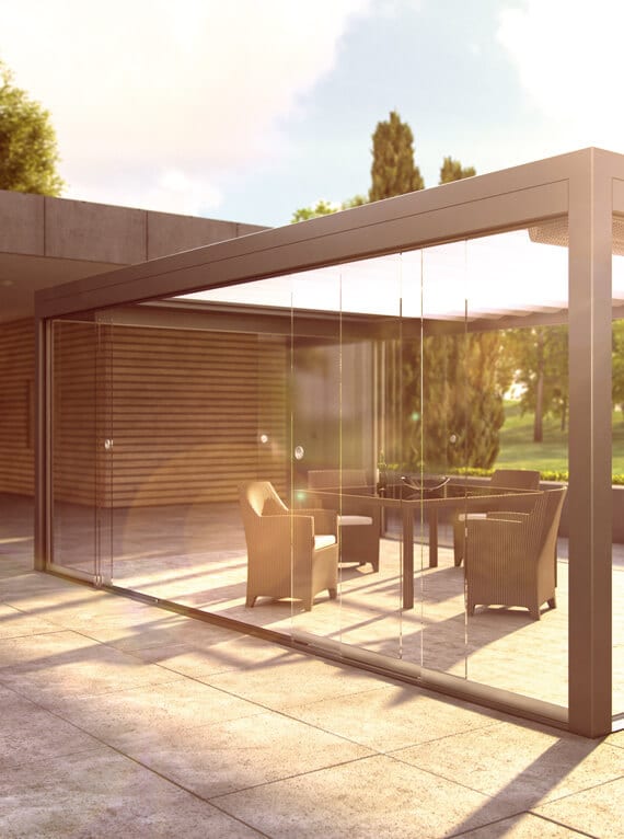 Rahmenlose Glasschiebewand als seitlicher Wetterschutz an einer modernen Alu-Pergola im Außenbereich