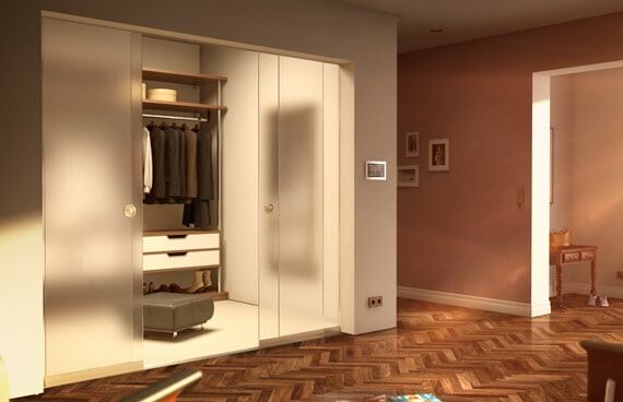 Rahmenlose Glasschiebetüren als eleganter Raumteiler vor einem begehbaren Kleiderschrank im modernen Wohnbereich