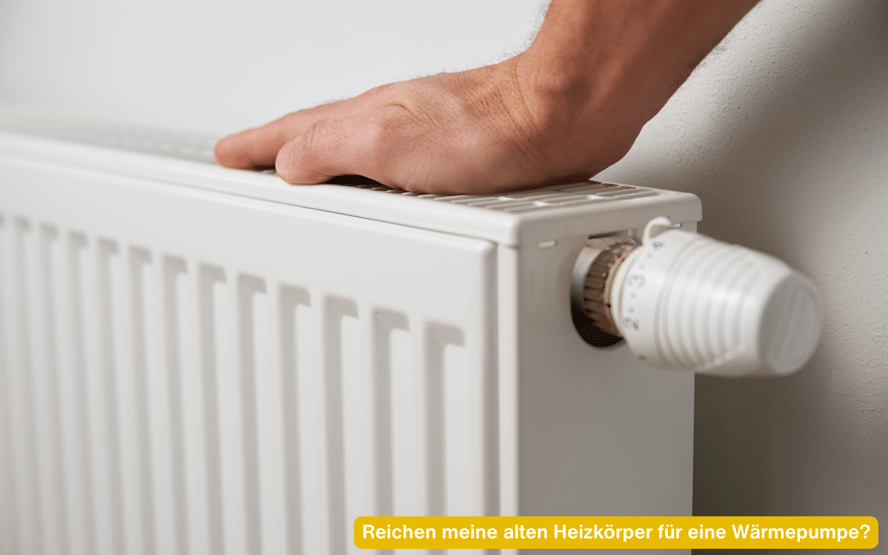 Reichen meine alten Heizkörper für eine Wärmepumpe? Hand prüft die Wärme eines Heizkörpers mit Thermostat
