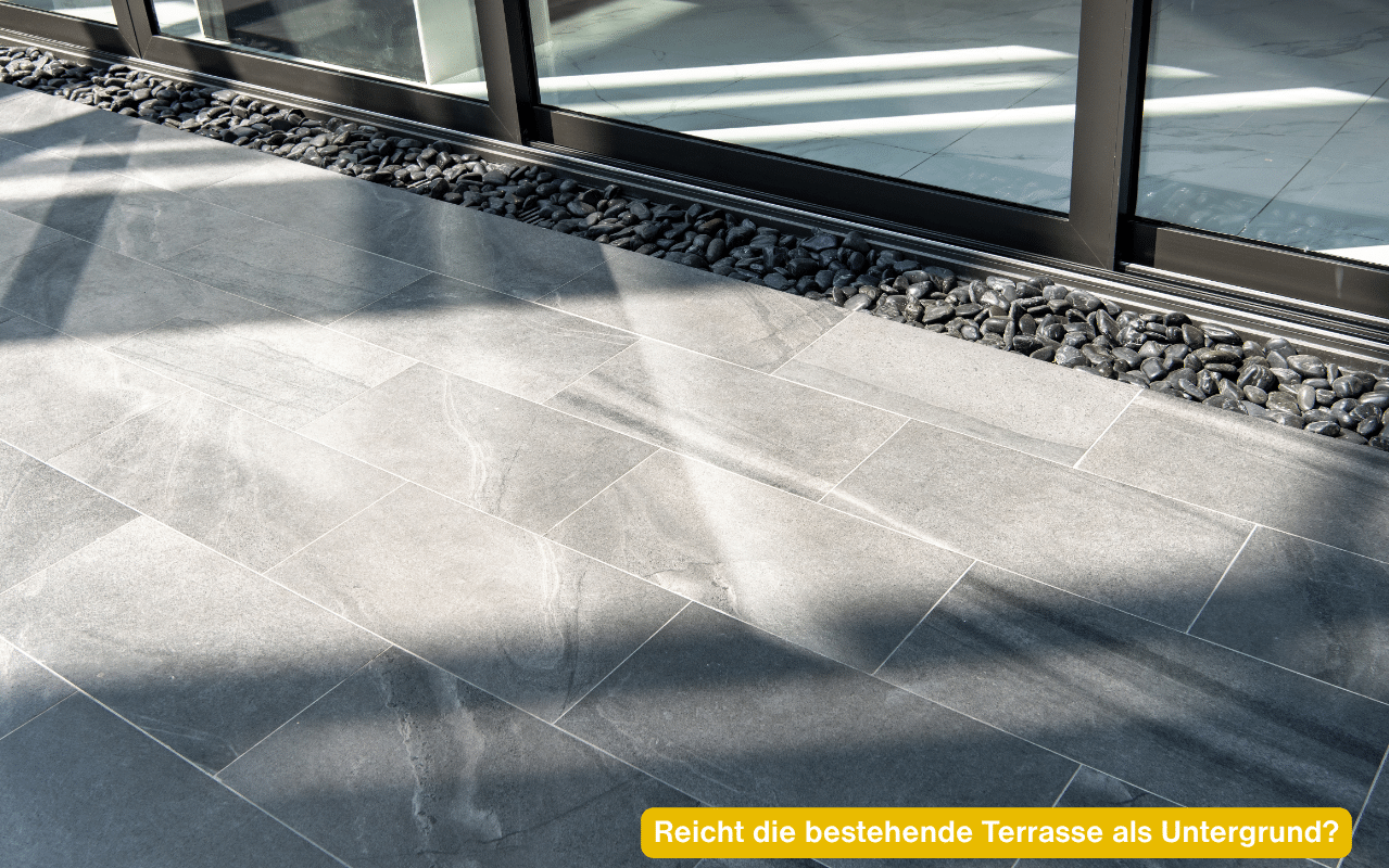Reicht die bestehende Terrasse als Untergrund? Leere Terrasse mit Steinplatten vor großen Glastüren