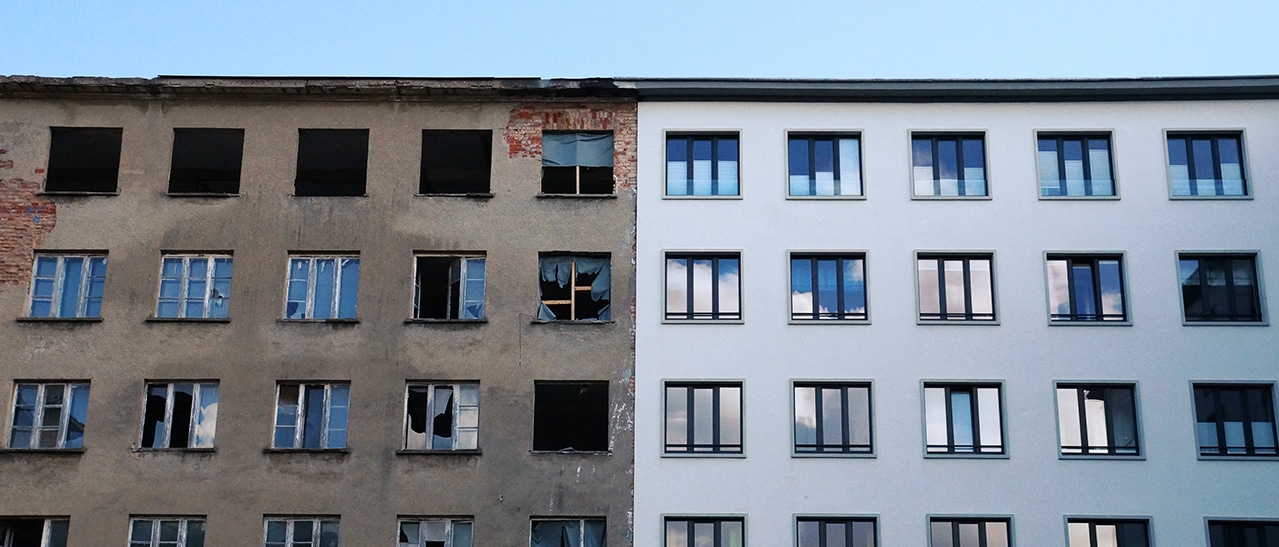 Revitalisieren mit Blick in die Zukunft Fenster mit 3-fach Verglasung zeigen Sanierungsunterschied zwischen Altbau und modernisiertem Gebäude.