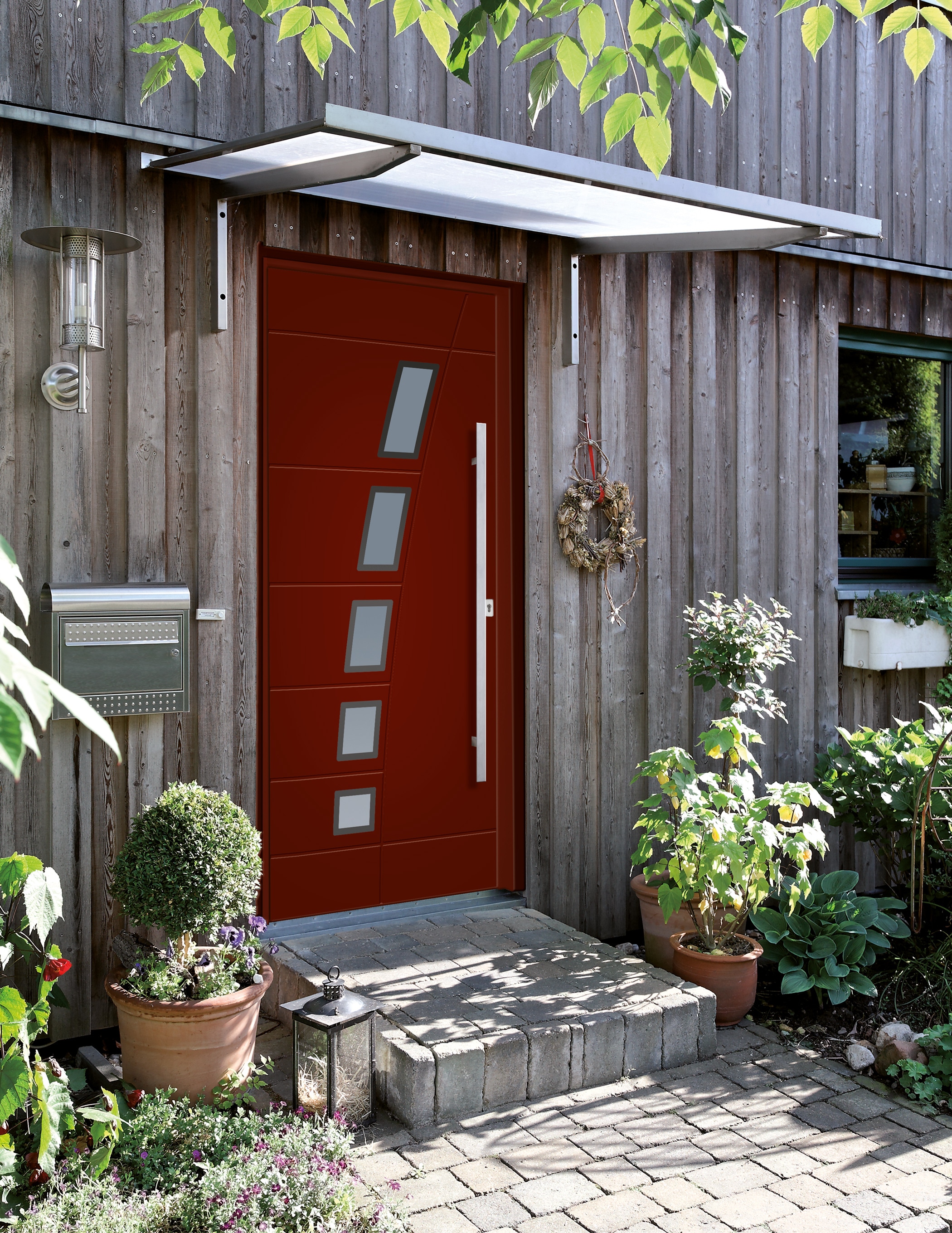 Rote Aluminium Außentüre mit Glasfeldern in Milchglas - Montiert in ein Holzhaus
