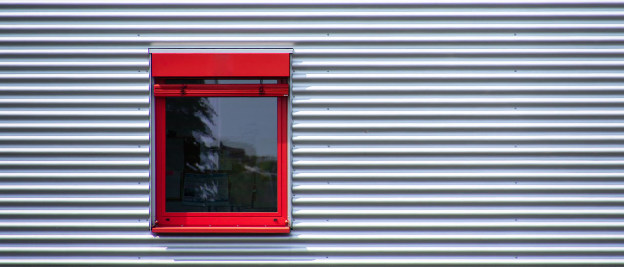 Rote Fenster in einer Aluminium Fassade