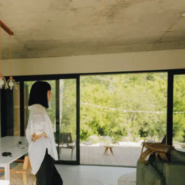 Schiebetür oder Flügeltür im modernen Wohnraum mit großflächiger Glasfront und Ausblick auf Terrasse und Garten.